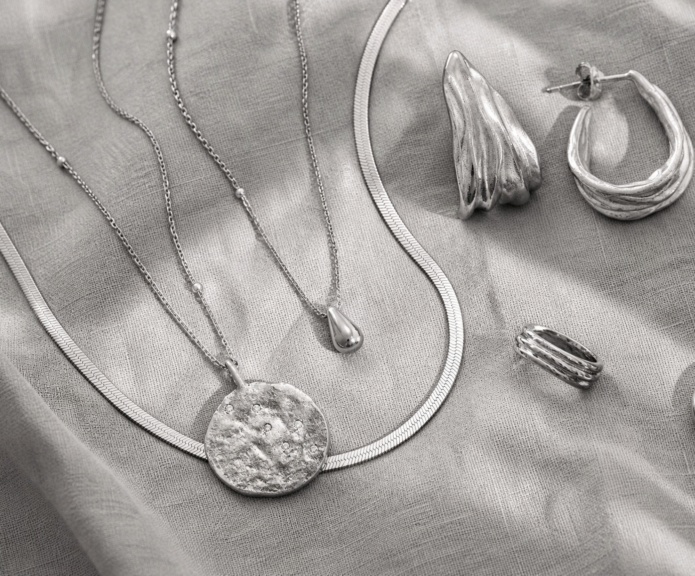 Curated jewellery collection arranged in monochrome editorial styling.