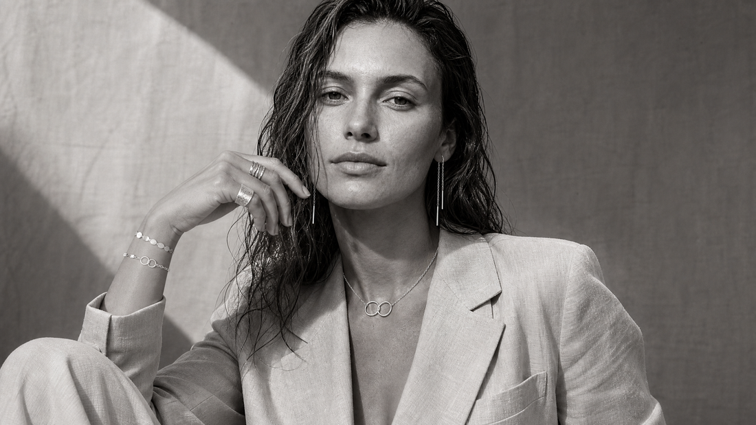 Woman wearing layered jewellery with relaxed everyday styling in monochrome photography.