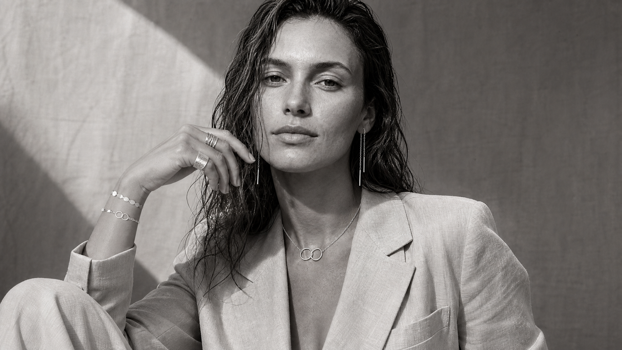 Woman wearing layered jewellery with relaxed everyday styling in monochrome photography.