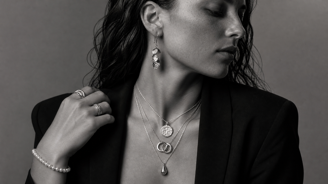Sculptural layered jewellery styled in monochrome editorial photography.