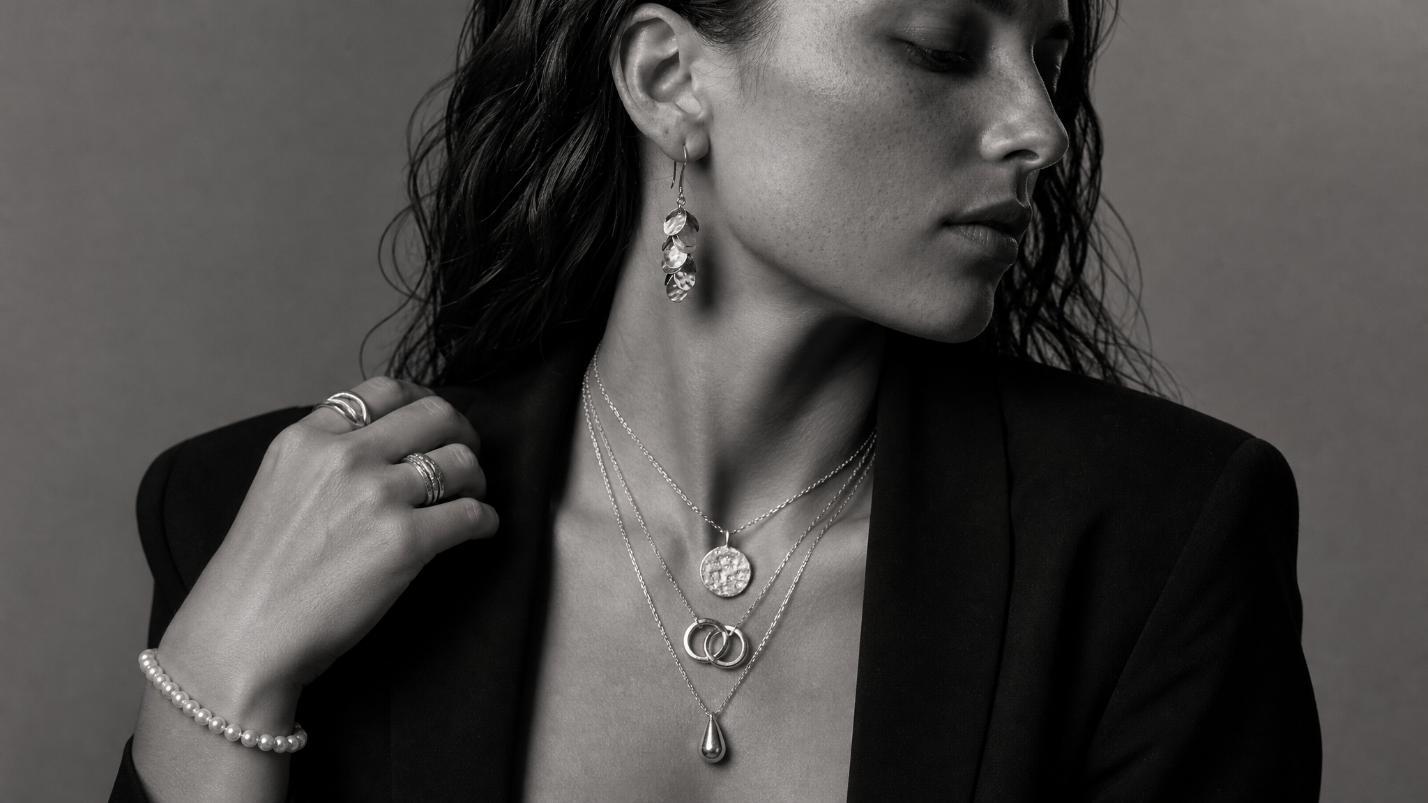 Sculptural layered jewellery styled in monochrome editorial photography.