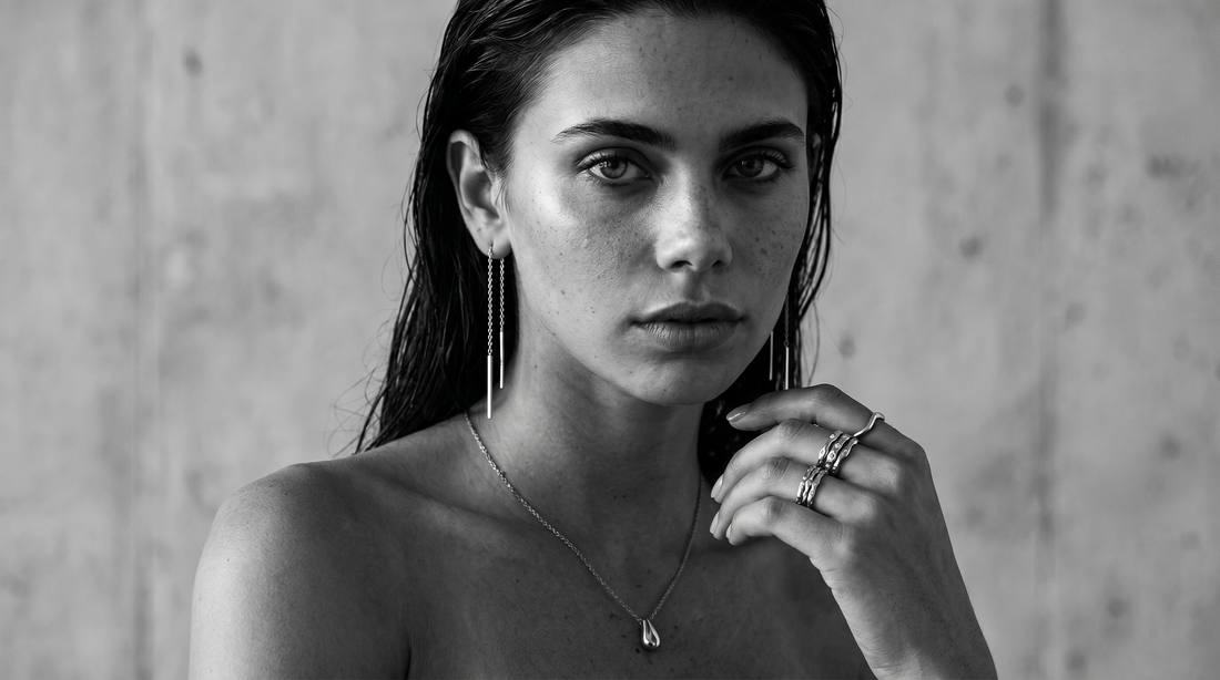 Woman wearing sculptural jewellery in black and white styling.
