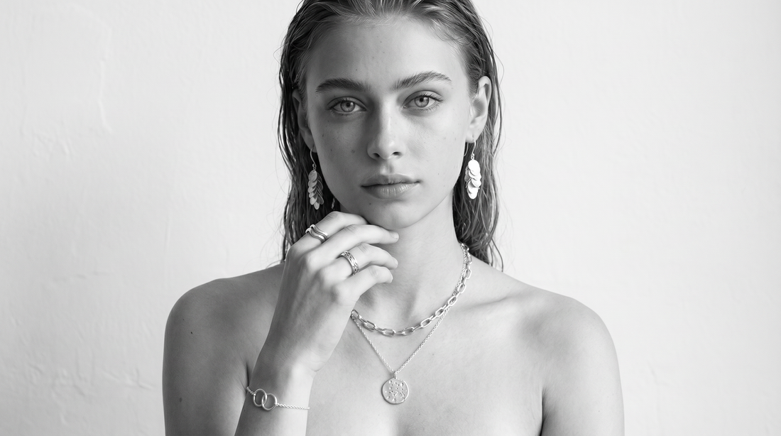 Woman wearing mixed metal jewellery in black and white editorial styling.