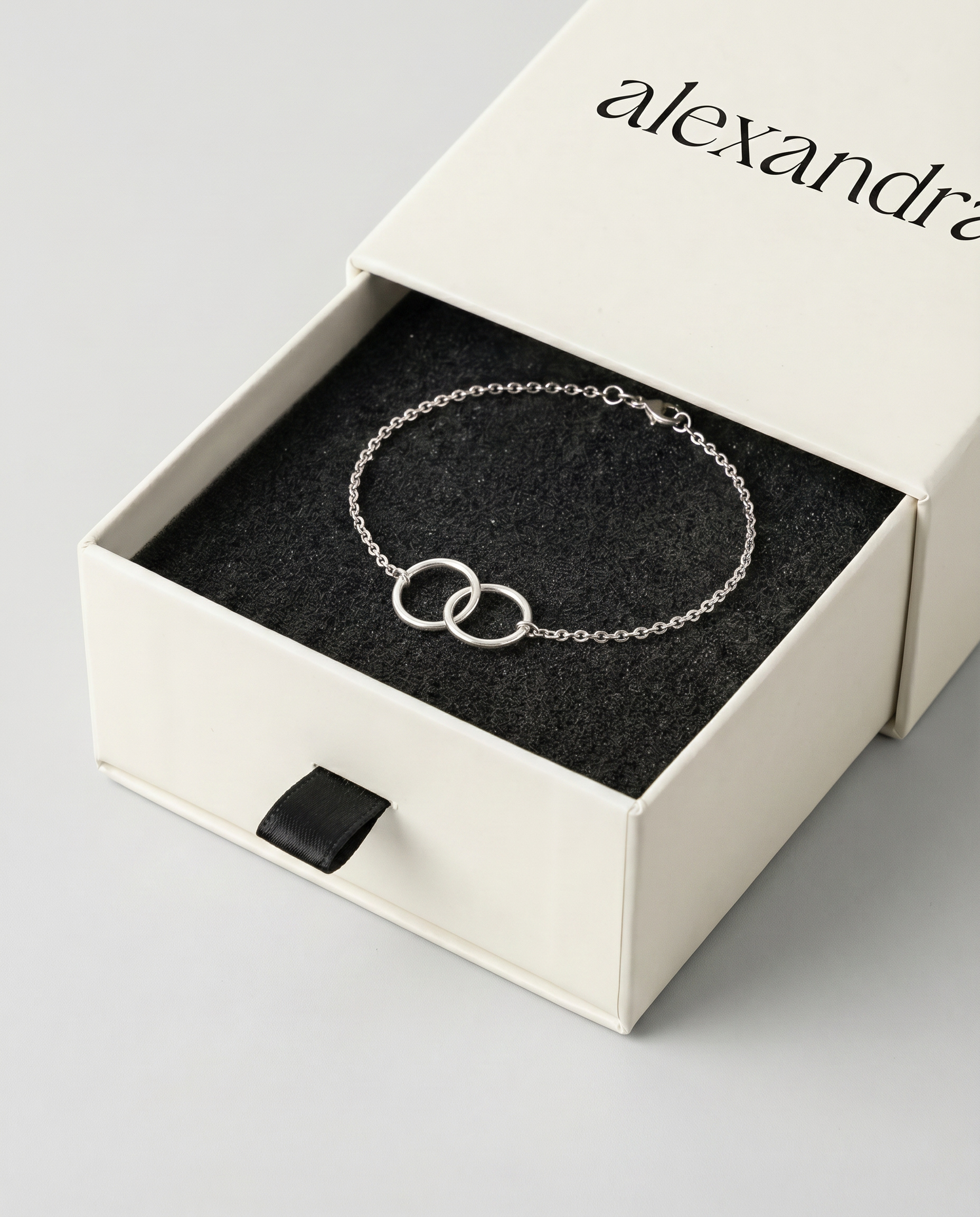 Silver bracelet in a branded box on a light gray background