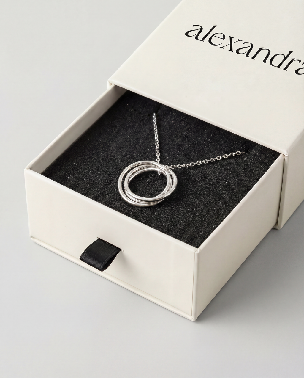 Silver necklace with trio of circular pendant in an open box