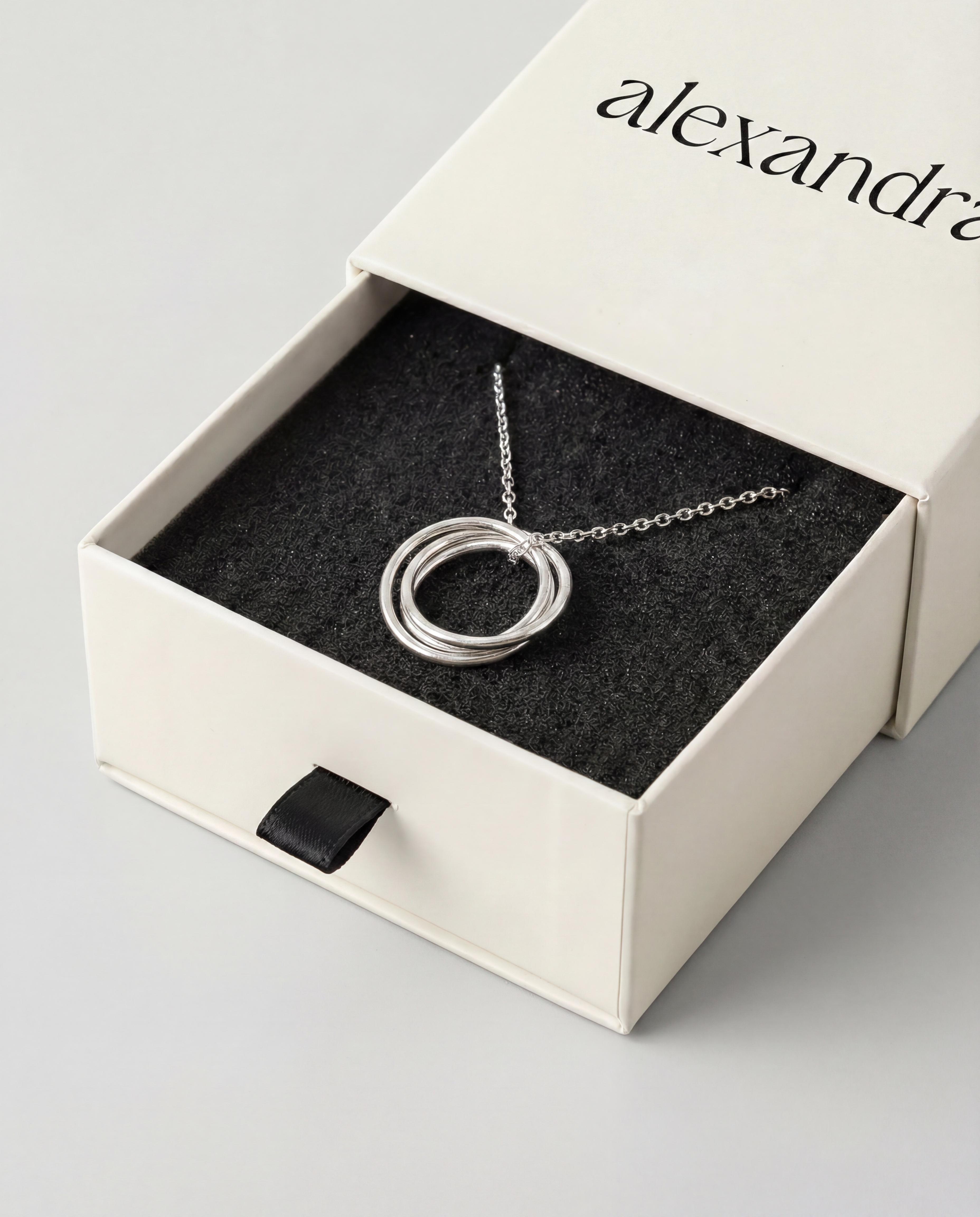 Silver necklace with trio of circular pendant in an open box