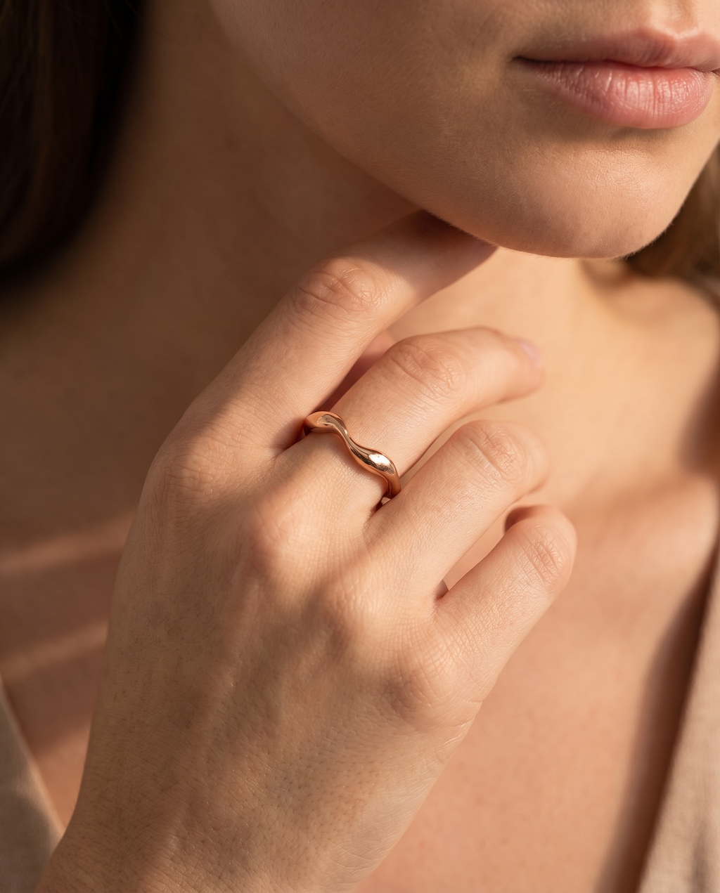 Luxury Rose gold ring on a woman's finger with a soft focus background