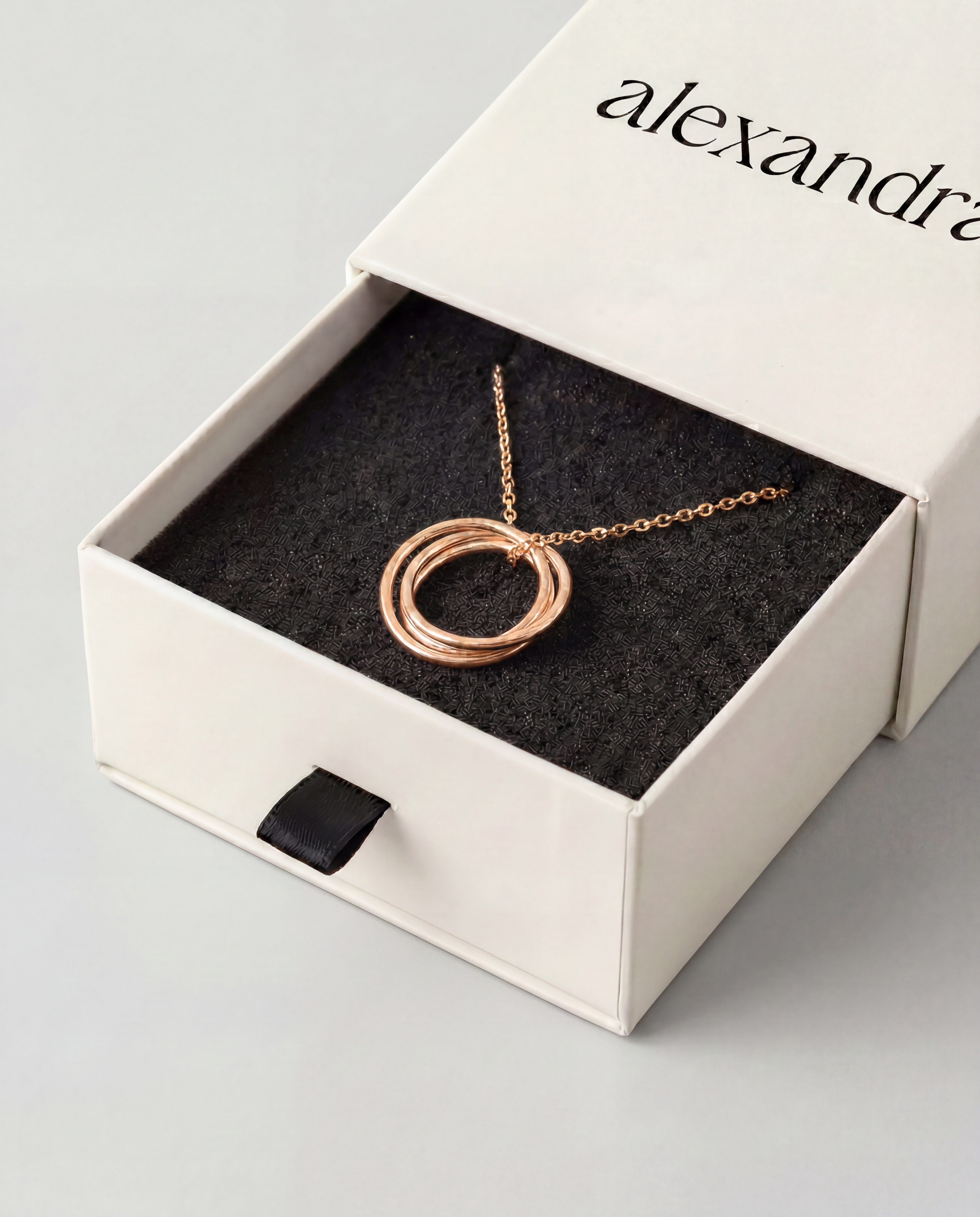 Sculptured Rose gold necklace in an open box with 'alexandra' branding.