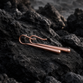 Refined Rose gold drop earrings on a dark, textured surface