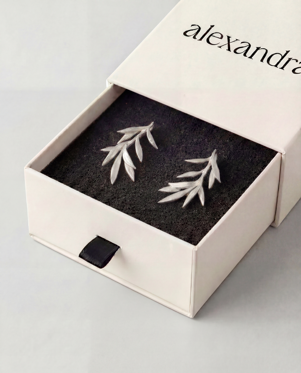 Sculptured Silver leaf earrings in a "alexandra" branded box on a light grey background
