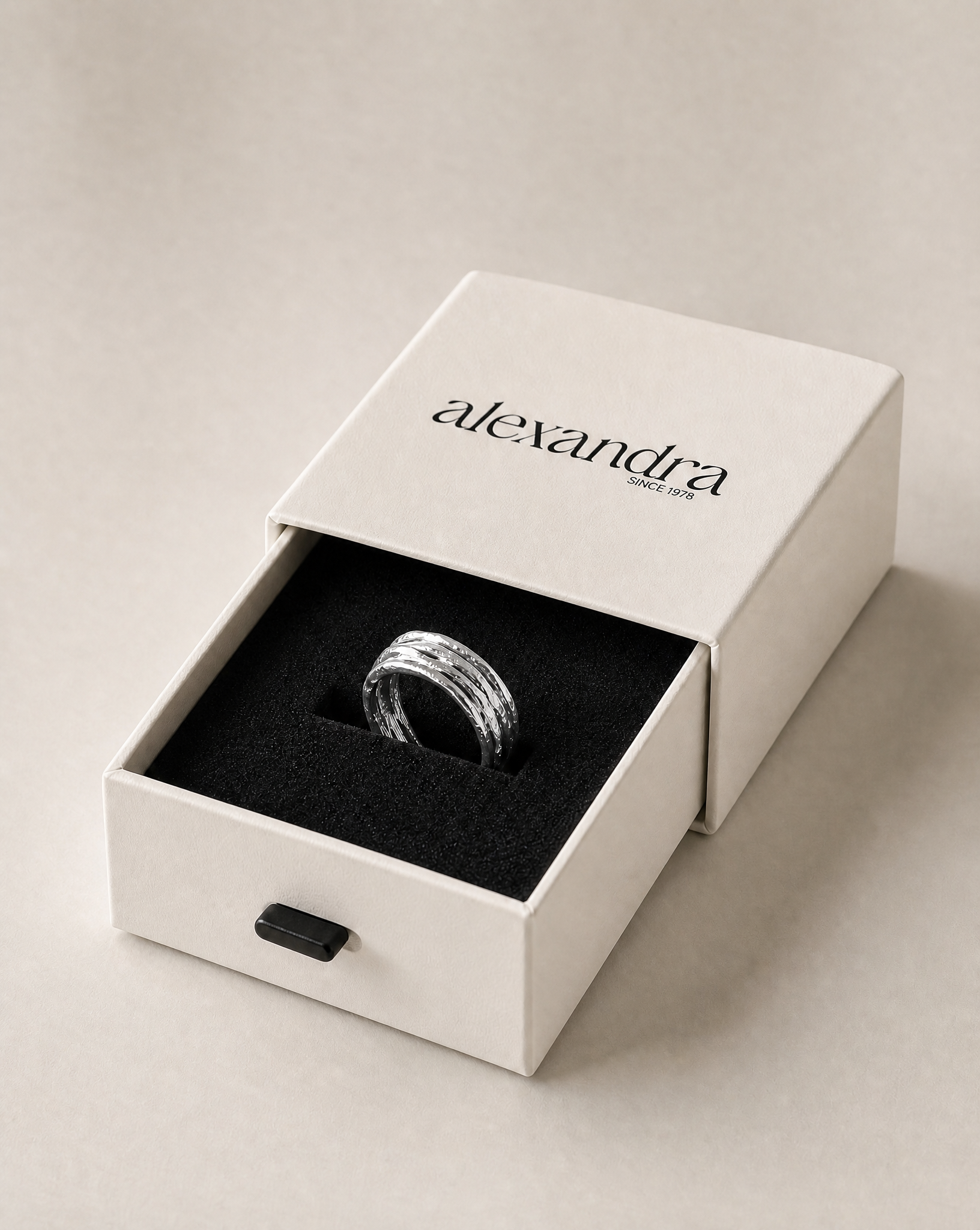 Rippled Silver ring in a 'alexandra' branded box on a light background